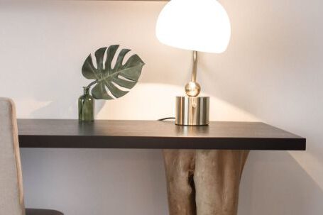 Furniture - Stainless Steel Base White Shade Table Lamp on Brown Wooden Desk Near White Painted Wall With Wall Mounted Flat Screen T V