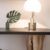 Furniture - Stainless Steel Base White Shade Table Lamp on Brown Wooden Desk Near White Painted Wall With Wall Mounted Flat Screen T V