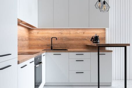 Kitchen Renovation - Contemporary interior of modern kitchen with comfortable white furniture and geometrical lamps hanging on ceiling