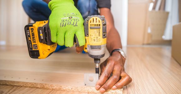 Renovation Tips - Person Using Dewalt Cordless Impact Driver on Brown Board